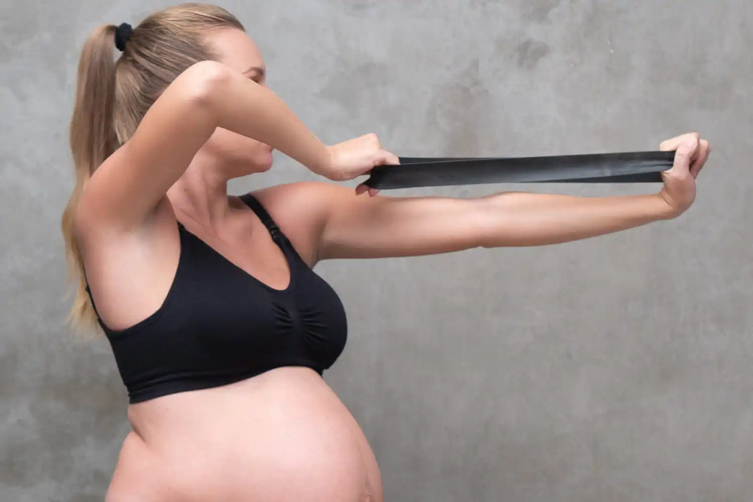 Gravid kvinna stretchar med band.