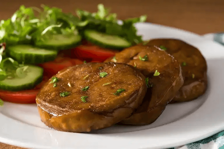 Seitan hamburgare och sallad på en tallrik.