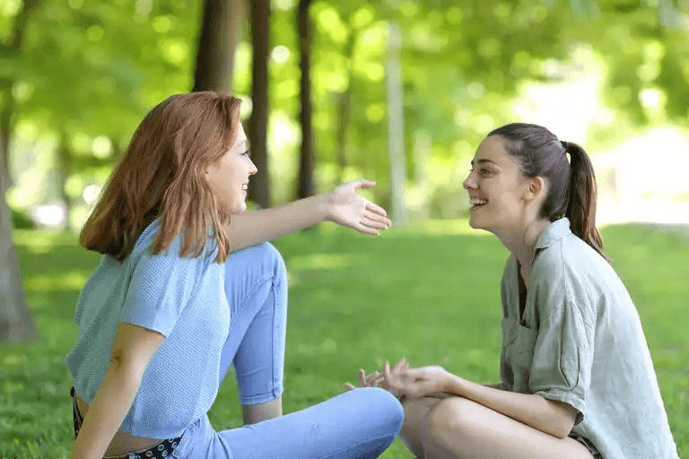 två kvinnor pratar i park