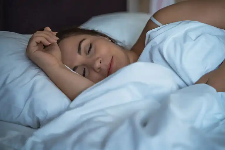 Kvinna sover djupt i sängen.