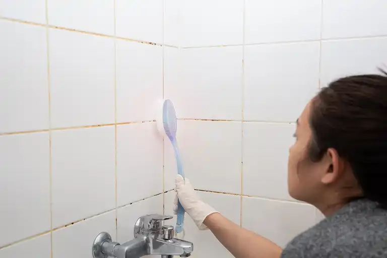 Kvinna som städar badrum